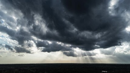 aerial time lapse of clouds with god rays and sun rays coming through. - Powered by Adobe