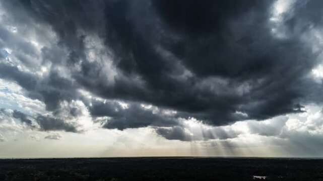 aerial time lapse of clouds with god rays and sun rays coming through.