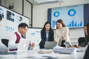Asian businesspeople working and brainstorming together in office meeting room using laptop...