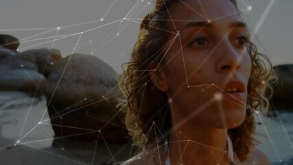 woman turning head tracking sun on shoreline as camera panning animating tech overlay glowing