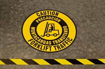 Caution Forklift Traffic sticker tape on warehouse floor warning safety signs.