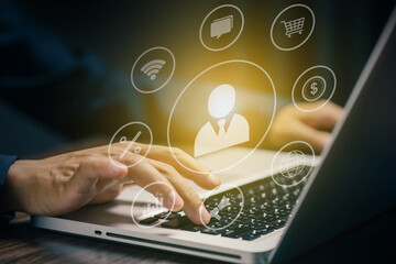 Hand typing on laptop keyboard with digital marketing icons overlay, representing online business, e-commerce, customer relationship management, and digital communication.