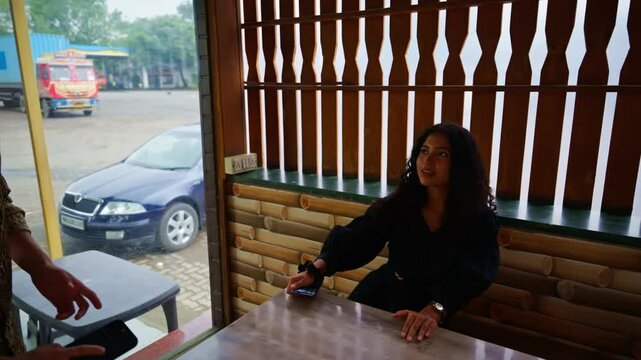 Couple enters cafe holding hands and sits across table