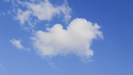 Cloudscape Serenity: A single, puffy cloud drifts peacefully across a vibrant blue sky, evoking a sense of calm and serenity in this natural, atmospheric scene.