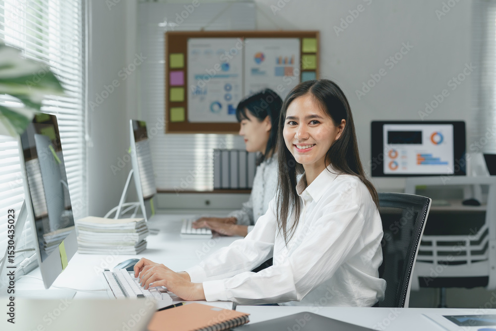 Aufkleber young businesswoman smiling and working with desktop computer in modern office with colleague workin