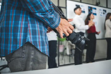 Photographer preparing to capture moments of a business team meeting in a modern office, focusing on collaboration and teamwork