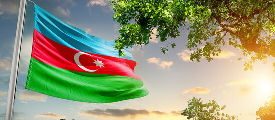 Azerbaijan flag waving in the sky. A couple hike and enjoy a break look at the top of the mountain adventure travel. Azerbaijan national flag for independence day.