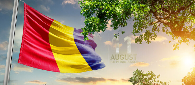 Chad flag waving in the sky. A couple hike and enjoy a break look at the top of the mountain adventure travel. Chad national flag for independence day. - Powered by Adobe