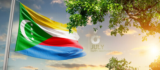 Comoros flag waving in the sky. A couple hike and enjoy a break look at the top of the mountain...