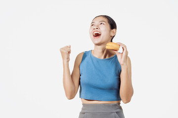 A confident young Asian woman in a sleeveless blue shirt stands against a white background, happily...