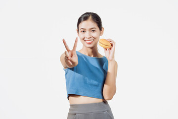 A confident young Asian woman in a sleeveless blue shirt stands against a white background, happily...