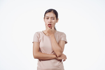 Obraz premium A confident young Asian woman in a light brown shirt stands against white background, experiencing toothache. Dental pain can result from cavities, gum disease, wisdom teeth, or nerve inflammation.