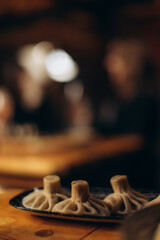 Plate of Steamed Dumplings in a Warmly Lit Restaurant Setting