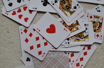 Playing cards, the deck is scattered chaotically on the floor.