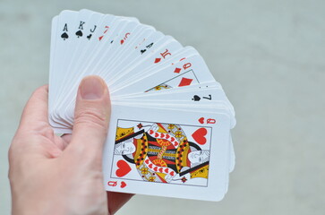 Playing cards in hand on a light background