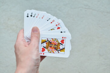 Playing cards in hand on a light background