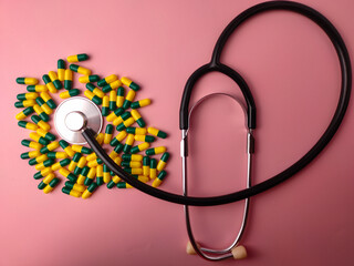 Top view statehoscope and medicine pill on a pink background