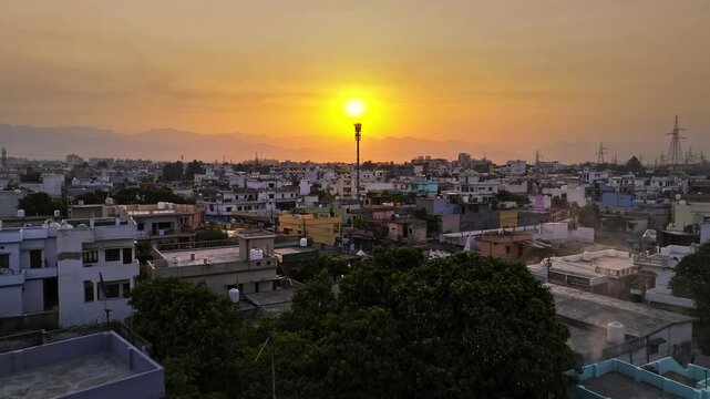 An aerial view of the picturesque city of Dehradun in Uttarakhand, India, captured during a breathtaking sunrise. The cinematic shot showcases the city's blend of urban charm and natural beauty.