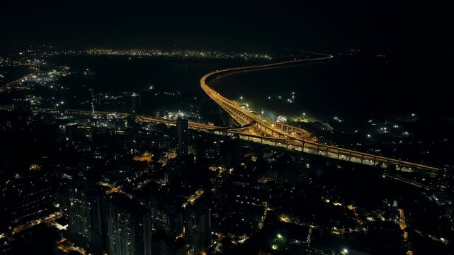 India's longest sea bridge: Trans-Harbour Sea Link. Atal Setu sea bridge in Mumbai, Maharashtra, India. Time-lapse of a city at night with bright skyscrapers and a dense network of glowing buildings.