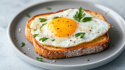 A delicious fried egg perched atop golden toast, garnished with black pepper, making for a comforting breakfast image that appeals to food lovers and home cooks alike.