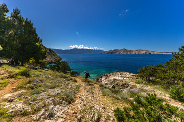 Jablanova Beach on the island of KRK in Croatia, blue trail leading to an empty pebble beach,