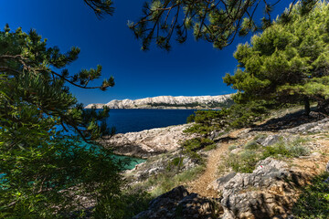 Jablanova Beach on the island of KRK in Croatia, blue trail leading to an empty pebble beach,
