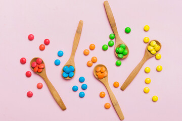 delicious colorful sweet candies on spoon on colored background . Confectionery decor top view with copy space