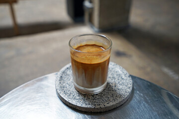 Close up glass of Dirty Latte coffee on ceramic tray