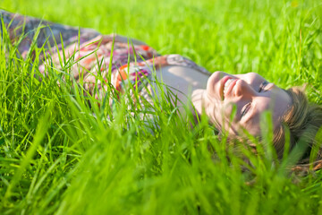 Winsome Young Caucasian Blond Female Resting Relaxed Over Green Grass Background