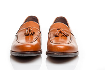 Mens Footwear Concepts. Closeup View of Pair of Traditional Formal Stylish Light Brown Polished Calf Leather Tassel Loafer Shoes On White
