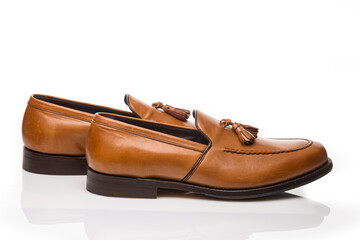 Footwear Concepts. Closeup View of Pair of Traditional Formal Stylish Light Brown Polished Calf Leather Tassel Loafer Shoes Placed On Pure White.