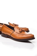 Footwear Concepts. Closeup View of Pair of Traditional Formal Stylish Light Brown Polished Calf Leather Tassel Loafer Shoes Placed On Pure White.