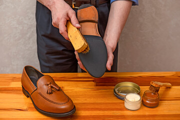 Footwear Concepts. Professional Male Shoes Cleaner with Cleaning Shoe Wax, Cream and Brushes For Tan Calf Leather Tassel Loafers Shoes While Working
