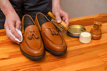 Closeup of Hands of Professional Male Shoes Cleaner with Cleaning Shoe Wax, Cream and Brushes For Tan Calf Leather Tassel Loafers Shoes While Working