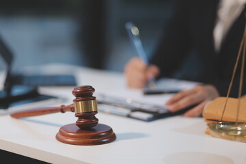 Fototapeta premium Judge gavel with Justice lawyers having team meeting at law firm background. Concepts of Law and Legal services.