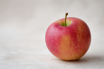 minimalistic photograph of single autumn apple on clean light background positioned slightly to right
