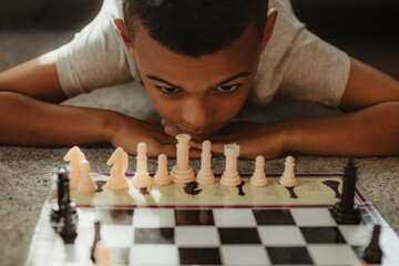 Young boy playing chess and concentrating