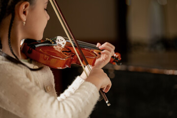 young girl plays the violin during a classical music concert.