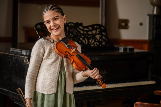 Young girl playing violin. Child musician practicing instrument.