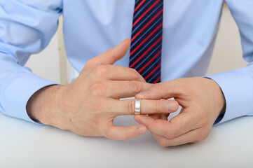 Man takes off his wedding ring, divorce separation concept