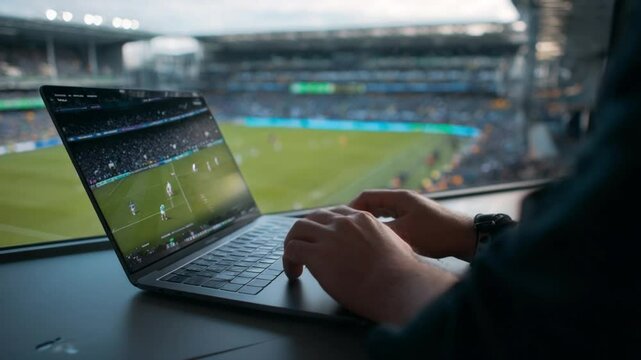 Live Sports Analysis: A close-up view shows hands typing on a laptop displaying a live soccer game, with the stadium in the background, signifying sports analysis.