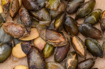 Roasted dark green pumpkin seeds without shell close up, macro
