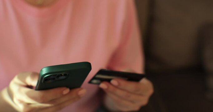 Close up of woman hand holding smartphone and credit card online shopping at home. Making purchase on smart phone e-banking service concept.