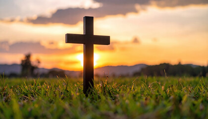 Black symbolic cross stands prominently against fiery sunset sky, creating striking silhouette that evokes sense of peace and reflection in serene landscape