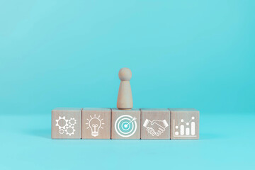 Wooden block target with teamwork icons, business goal setting concept, strategic planning for business growth, marketing strategy.  © buraporn