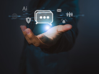 An ai chat message icon glowing above open hand with digital communication and security symbols in dark background, representing technology and connection