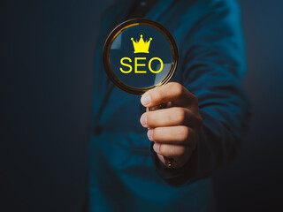A seo concept with magnifying glass held by person in blue suit, symbolizing search engine optimization and digital marketing strategy