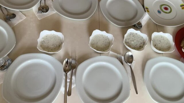 The woman serves cacik, made with cucumber and yogurt in the Turkish style, at the dining table.