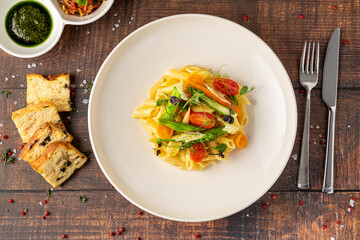 Creamy penne pasta with asparagus, cherry tomatoes and microgreens