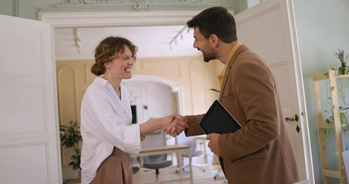 Smiling Business Professionals Initiate a Collaborative Partnership with a Firm Handshake in the Office